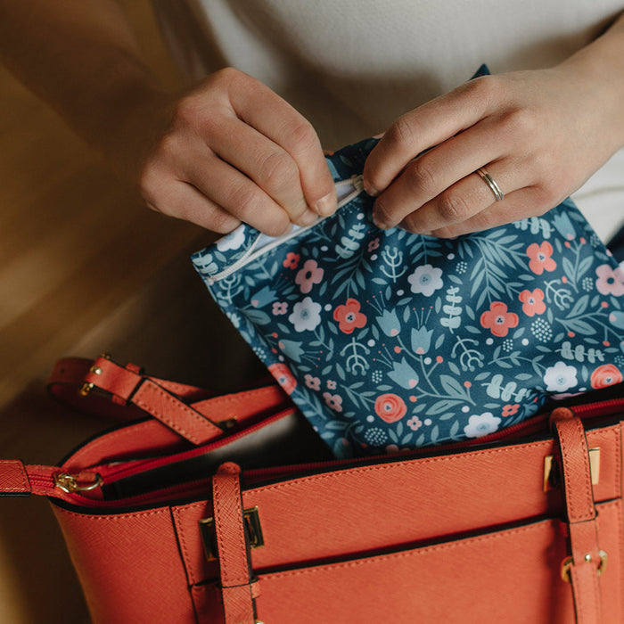 sac sandwich réutilisable fleuri dans les mains d'une femme qui le sort de son sac à main orange